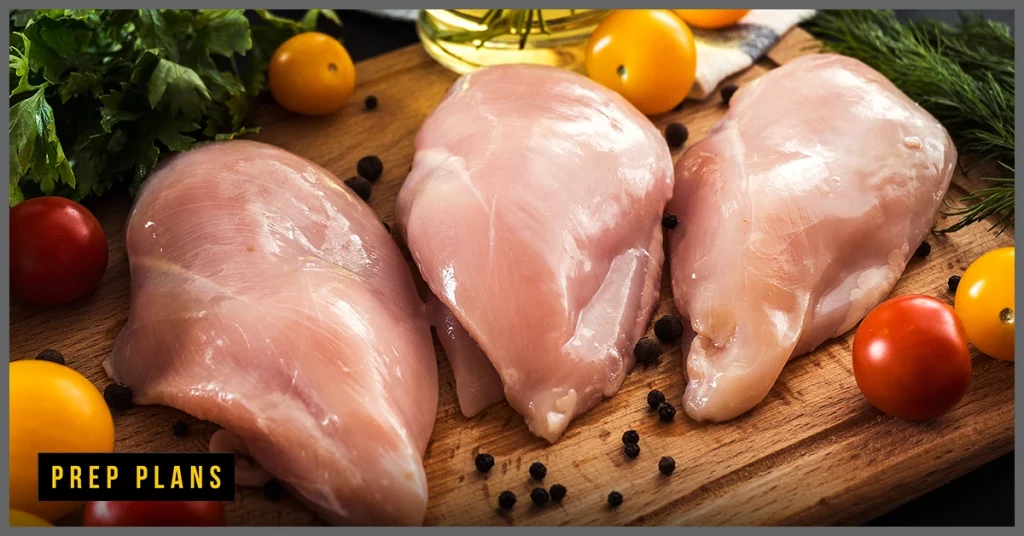 uncooked raw chicken on a wooden cutting board