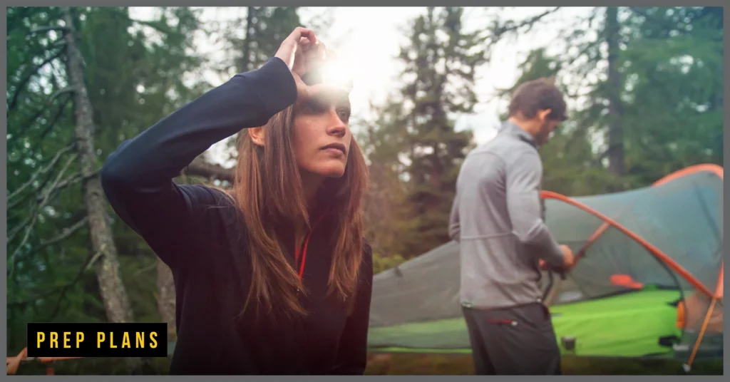 woman using a headlamp to light a hiking path