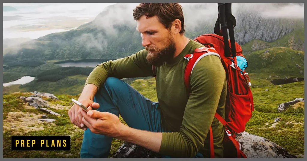 man using a prepaid burner phone in the mountains