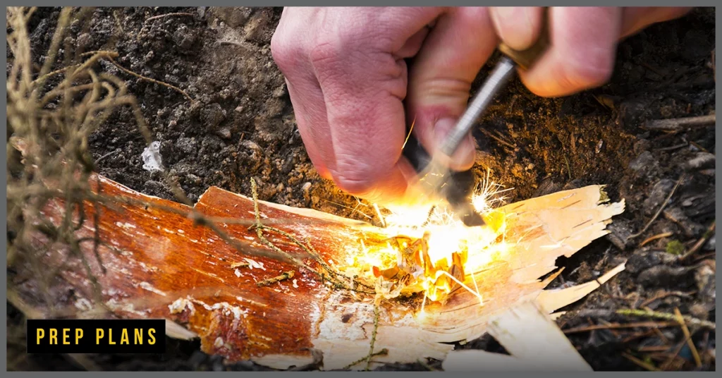 man using a fire starter in the wild bushcraft tools
